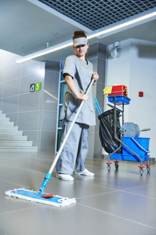 worker cleaning floor with machine